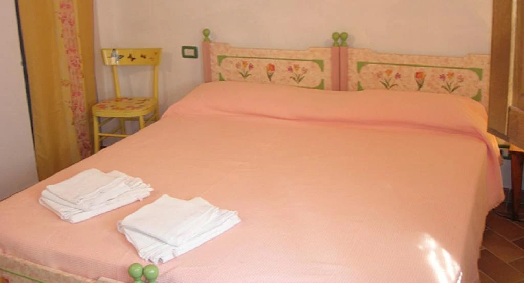 hartje-toscane-agriturismo-il-monte-la-capannina-slaapkamer-met-roze-bed-42-casamia