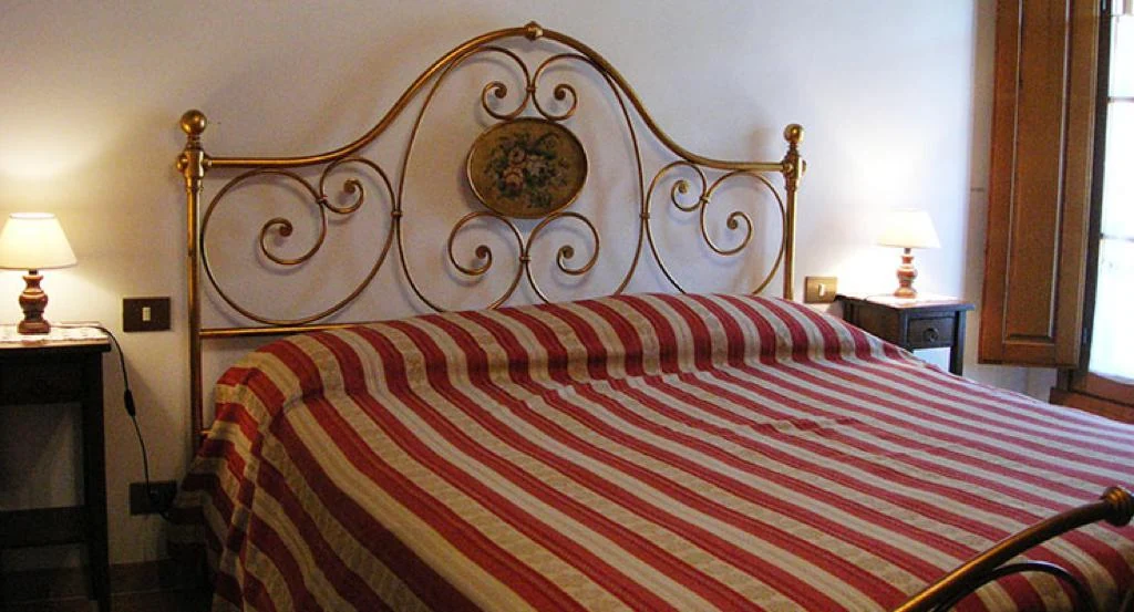 hartje-toscane-agriturismo-il-monte-terrazza-slaapkamer-met-gestreept-bed-60-casamia