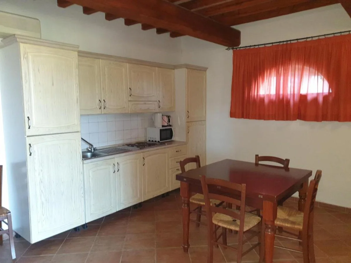 toscaanse-kust-borgo-di-montemurlo-quadrilocali-keuken-met-eethoek-en-rood-gordijn-048-casamia