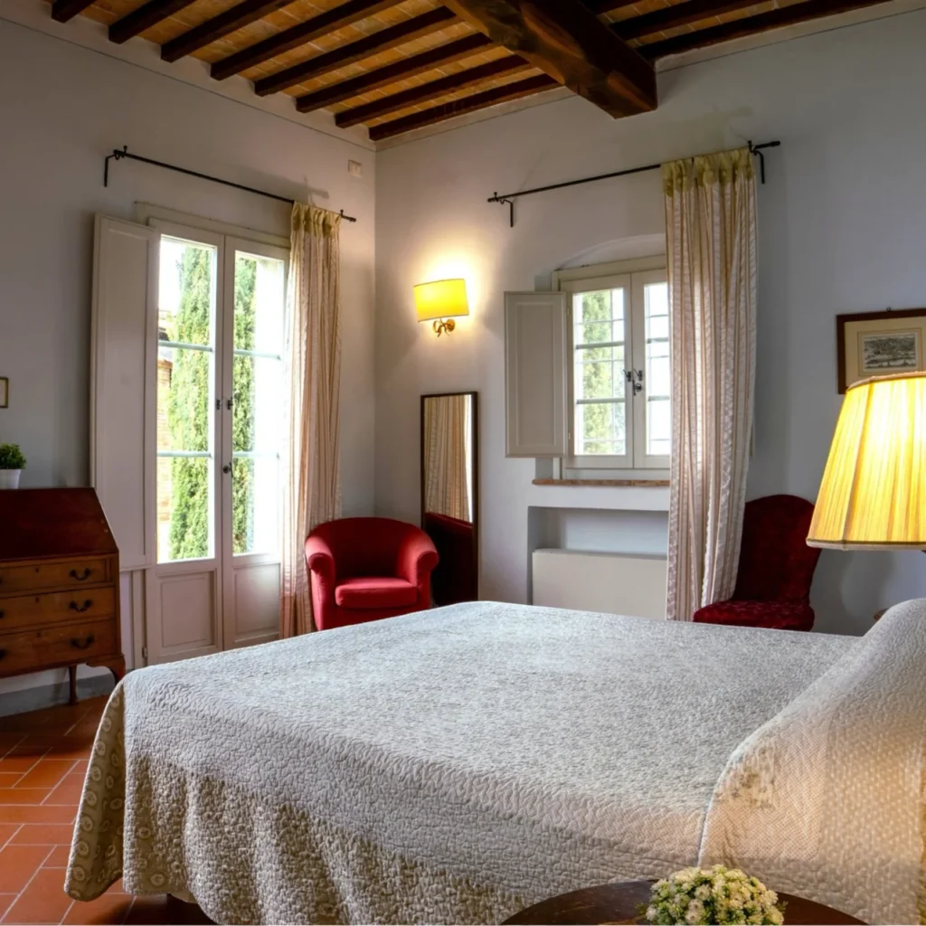 Hartje toscane borgo della meliana slaapkamer met tweepersoonsbed en rode fauteuil