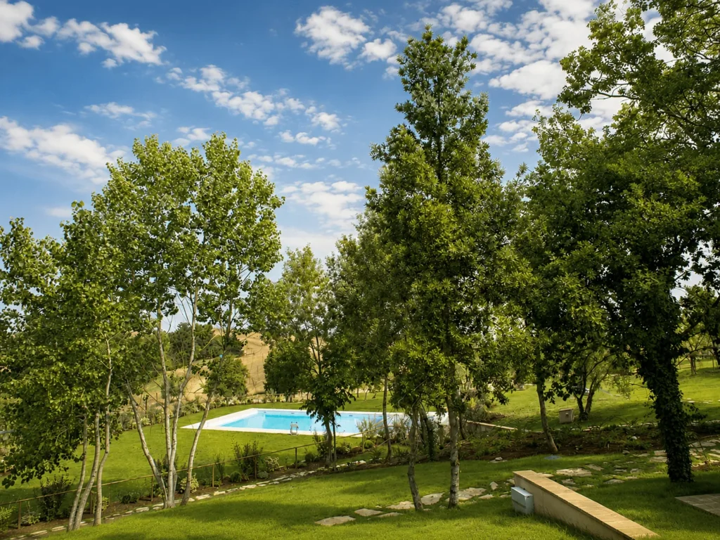 Hartje toscane borgo della meliana tuin met bomen en uitzicht op het zwembad