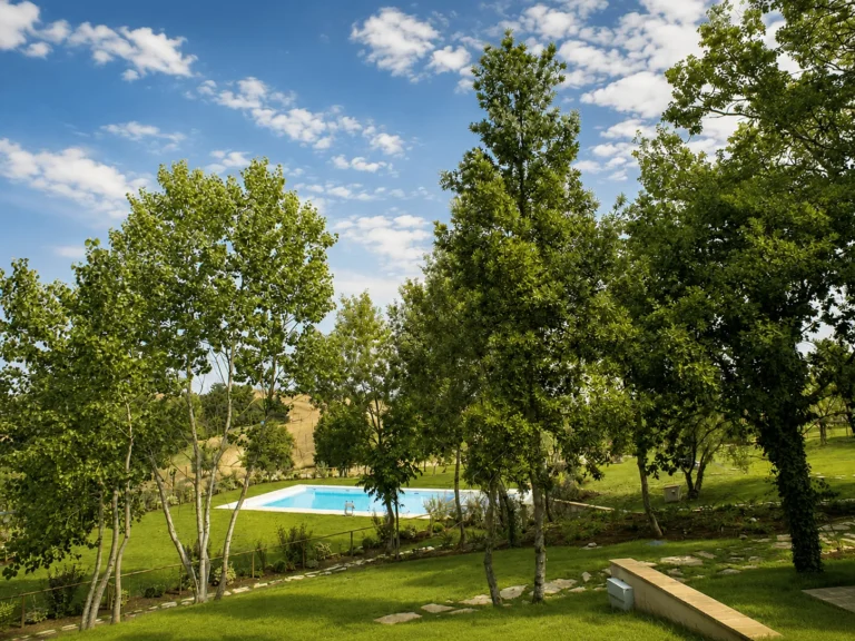 Hartje toscane borgo della meliana tuin met bomen en uitzicht op het zwembad