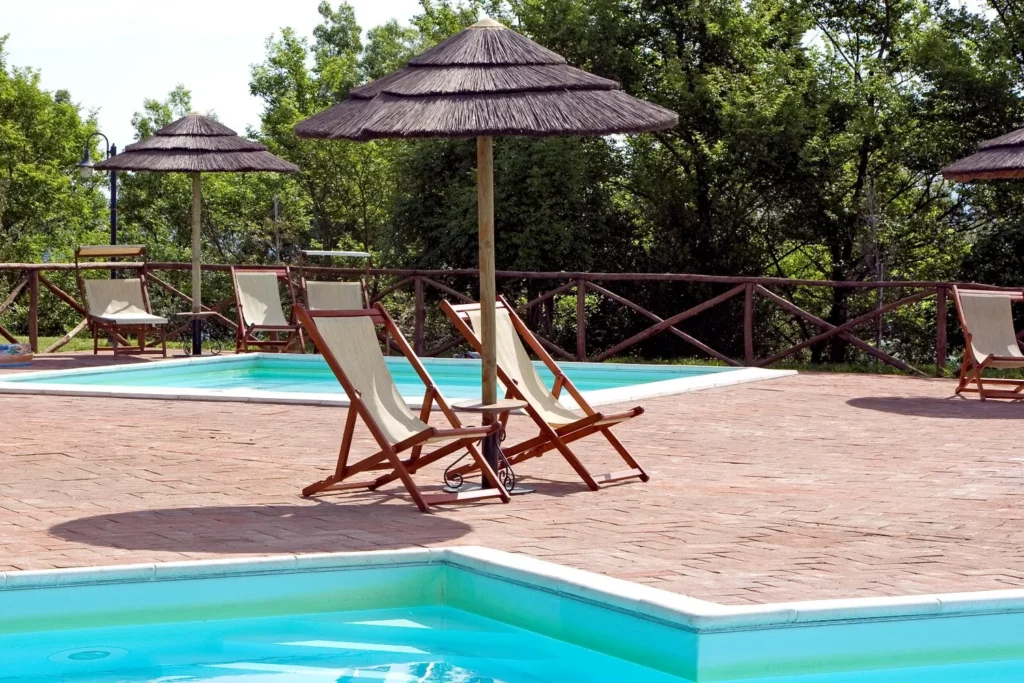 Toscaanse kust borgo di montemurlo ligstoelen en rieten parasols aan het zwembad