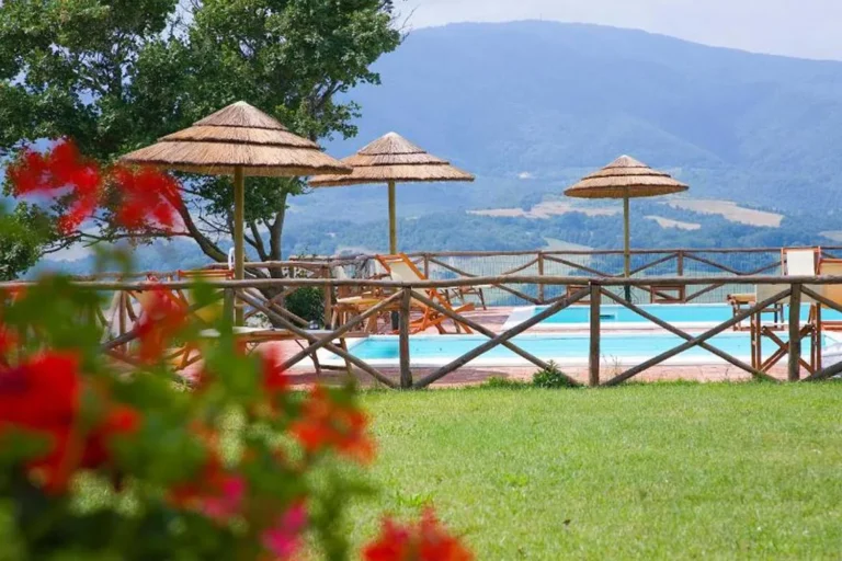 Toscaanse kust borgo di montemurlo zwembad met rieten parasols en bloemen