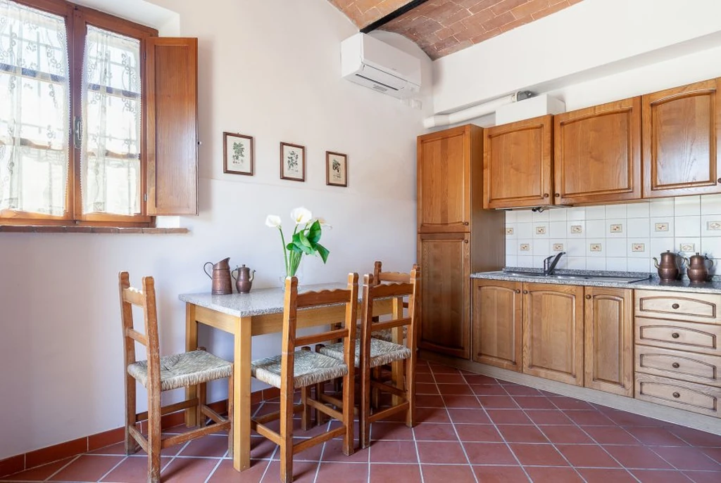 toscane-il-gattero-edera-eettafel-naast-keuken-met-houten-kasten-casamia
