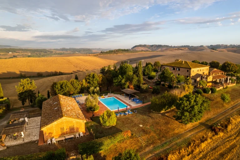 Toscane il gattero luchtfoto van gebouwen en zwembad tussen akkers