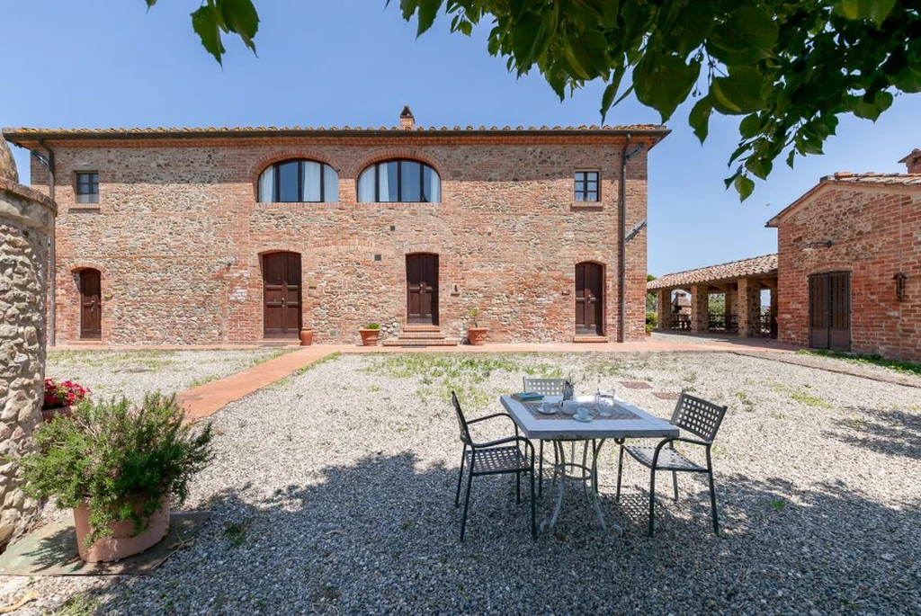 toscane-il-gattero-rosa-binnenplaats-met-tafel-voor-de-gevel-casamia