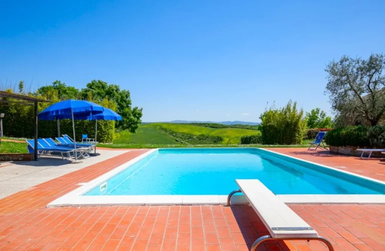 Toscane il gattero zwembad met blauwe parasol